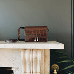 Chylak glossy brown crocodile leather belt bag at Palace of Nowhere